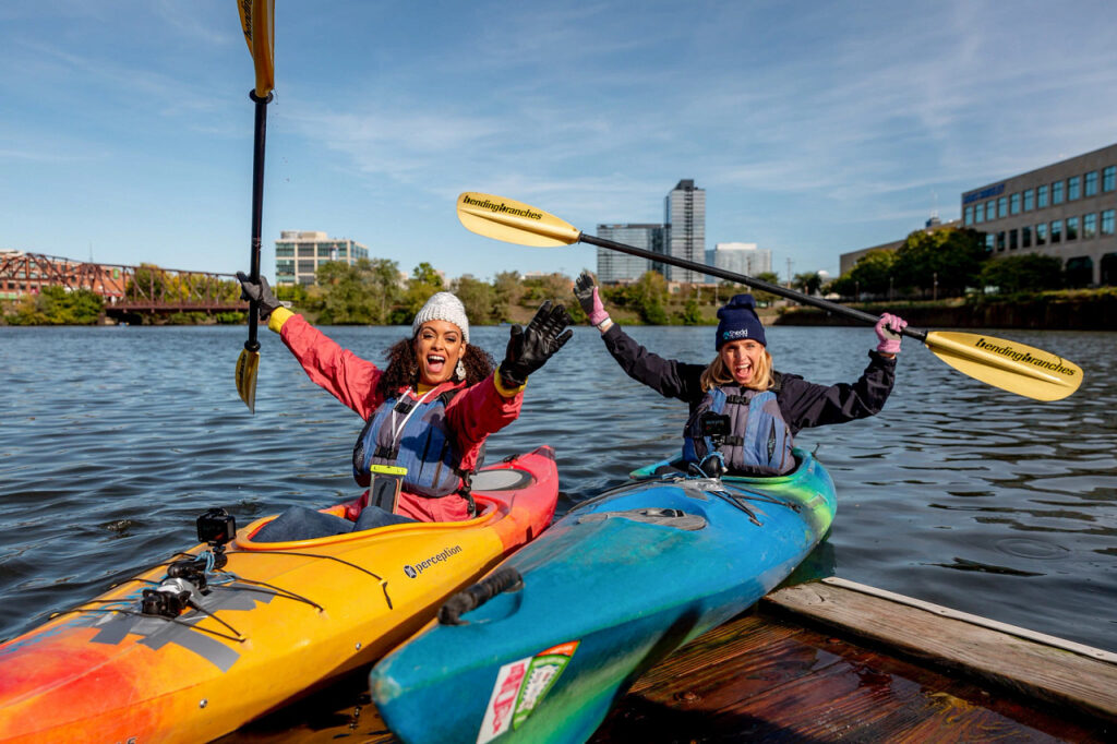 Two women in kayaks on the river.